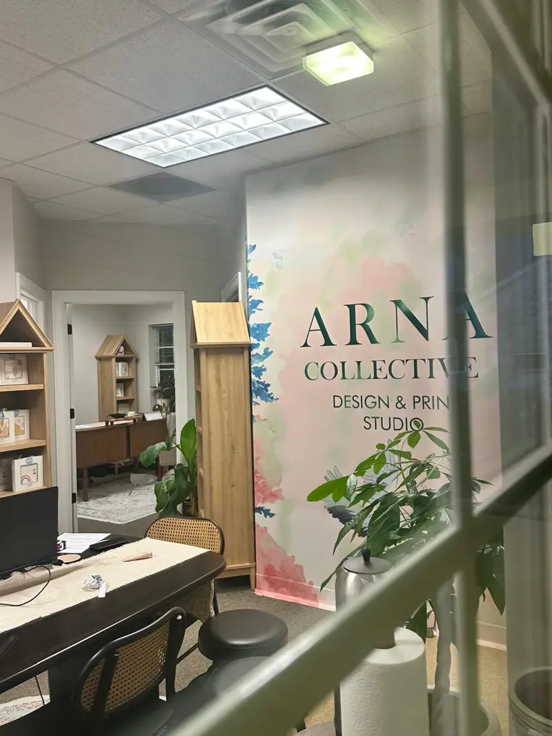 Inside the Arna Collective studio: a large-format printer, rolls of printed material and a work table